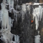 A Guy in an Orange Jacket Climbing the Ice at Casket Quarry in West Duluth
