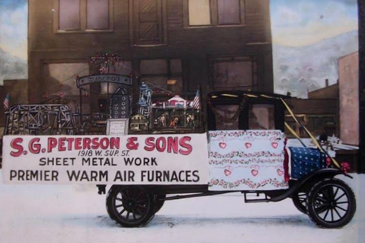 This painting by Edna Sandberg Peterson is a reproduction of an early 20th Century photo of S. G. Peterson & Sons entry in a local parade.