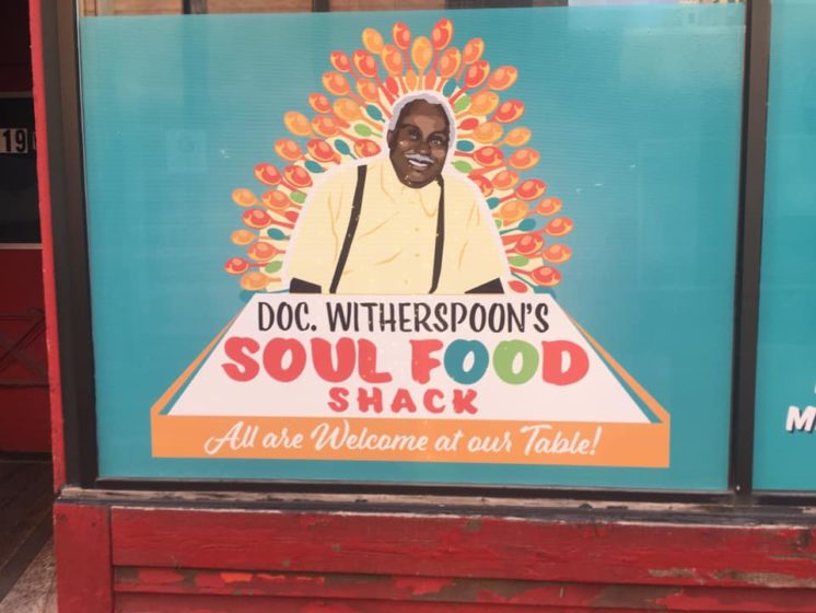 Doc Witherspoon's Soul Food Shack sign that reads: All are welcome at our table.