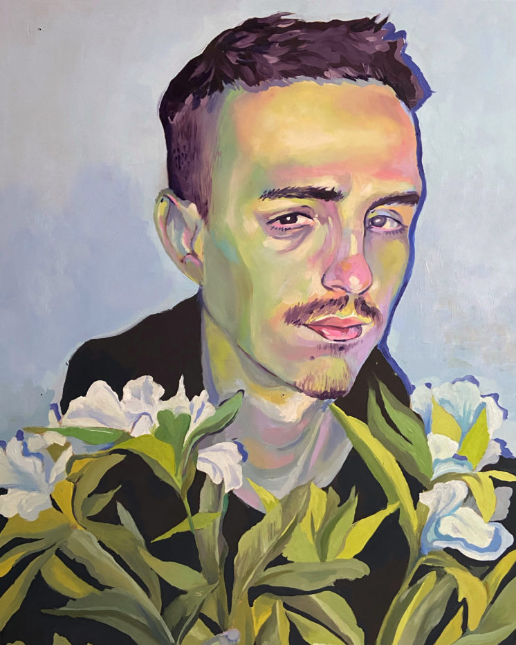 A man with short hair and a mustache looking sad with some flowers