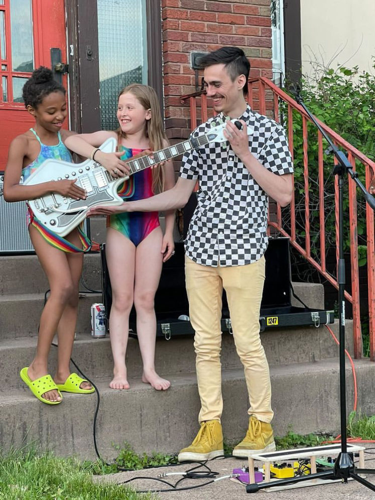 Dirbike Boyfriend showing his guitar to two young girls